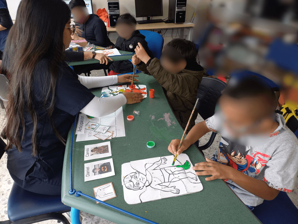 Estudiante en formación de la Licenciatura en Educación Especial durante la práctica de trabajo de grado con dos participantes del centro crecer. 